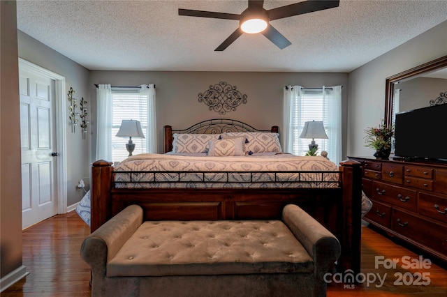 bedroom featuring hardwood / wood-style floors, a textured ceiling, and ceiling fan