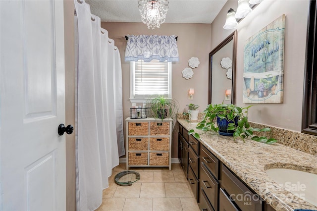 bathroom featuring tile patterned flooring, vanity, and a textured ceiling