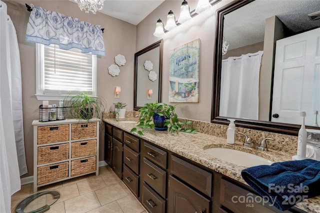 bathroom featuring tile patterned flooring, vanity, and a textured ceiling