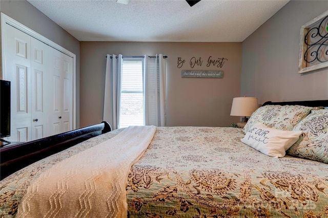 bedroom with a textured ceiling and a closet