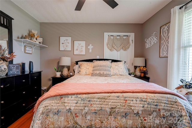 bedroom with multiple windows, a textured ceiling, and ceiling fan