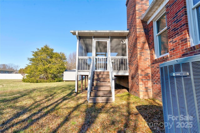 exterior space with central AC, a yard, and a sunroom