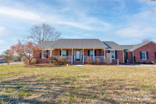 ranch-style home featuring covered porch and a front lawn