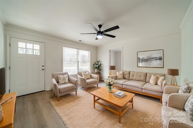 living room featuring ornamental molding, light hardwood / wood-style floors, and a wealth of natural light