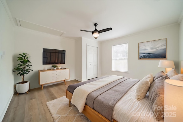 bedroom with ceiling fan, ornamental molding, light hardwood / wood-style floors, and a closet