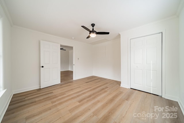 unfurnished bedroom featuring crown molding, light hardwood / wood-style flooring, ceiling fan, and a closet