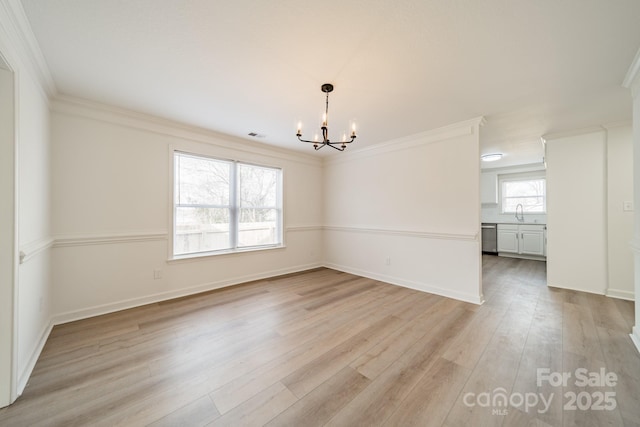 spare room with crown molding, sink, light wood-type flooring, and a notable chandelier