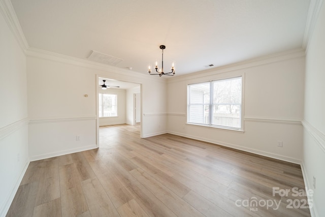 unfurnished room featuring ornamental molding, an inviting chandelier, and light hardwood / wood-style flooring