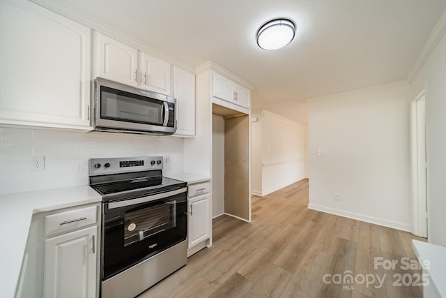 kitchen with white cabinetry, backsplash, stainless steel appliances, crown molding, and light hardwood / wood-style flooring