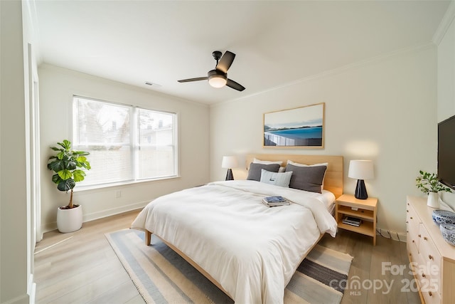 bedroom featuring ceiling fan, ornamental molding, and light wood-type flooring