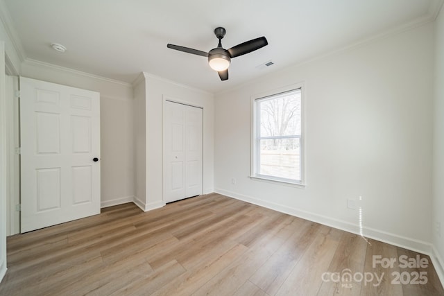 unfurnished bedroom with ornamental molding, light hardwood / wood-style floors, ceiling fan, and a closet