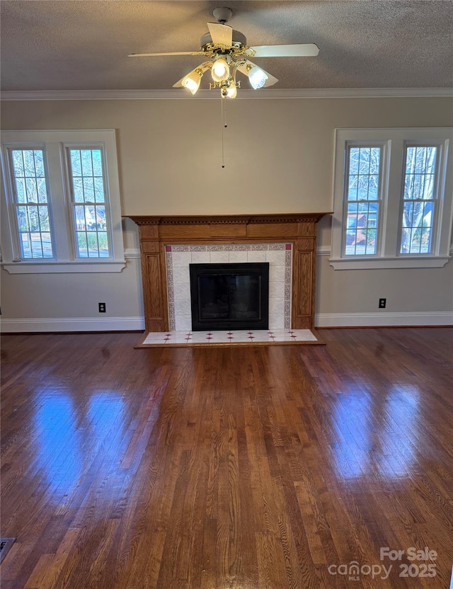 unfurnished living room with a textured ceiling, ornamental molding, and a tile fireplace