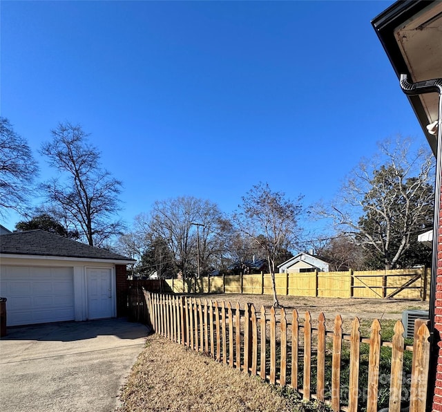 view of yard with a garage, central AC, and an outdoor structure