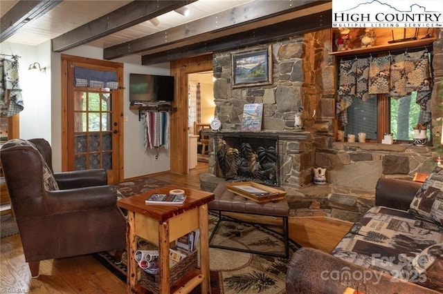 interior space featuring a fireplace, wood finished floors, and beamed ceiling