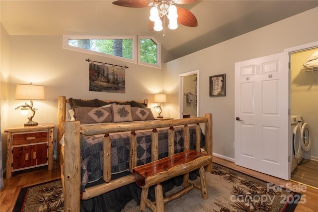 bedroom featuring ceiling fan, wood finished floors, baseboards, vaulted ceiling, and independent washer and dryer