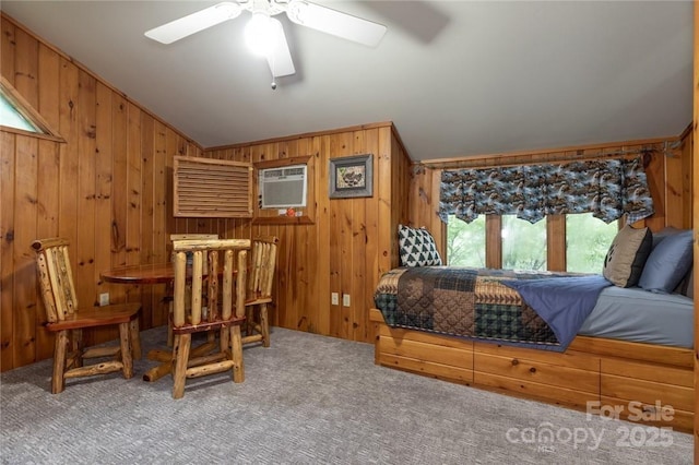 carpeted bedroom with a wall unit AC, wood walls, and vaulted ceiling