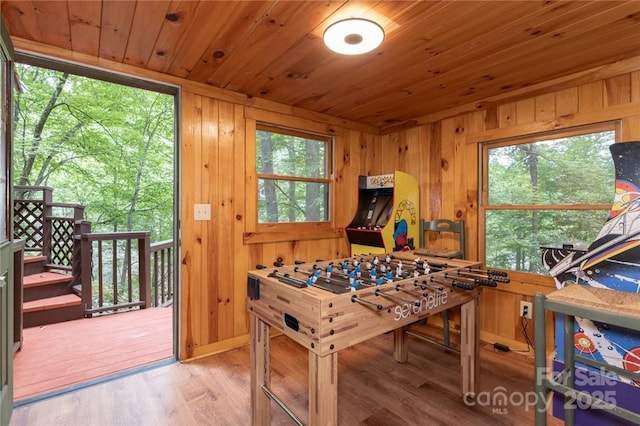 rec room featuring wood ceiling, wood walls, and wood finished floors