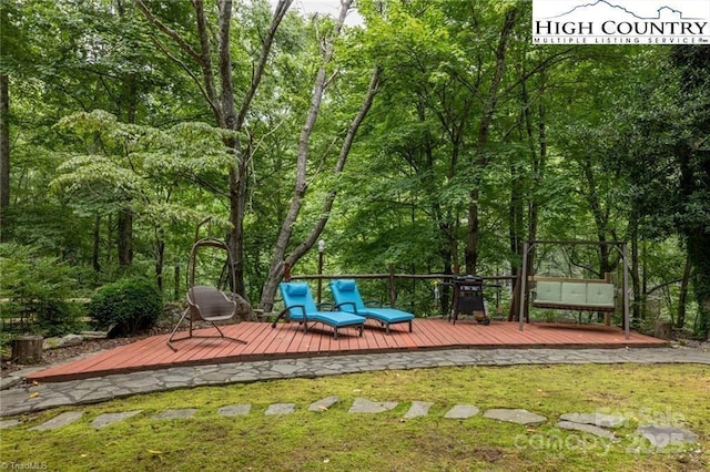 wooden deck featuring a lawn