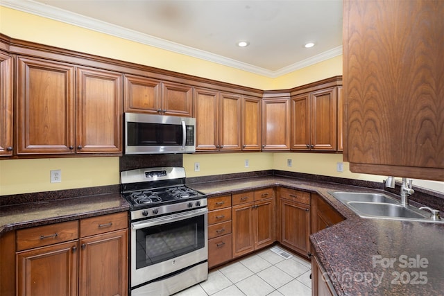 kitchen featuring dark stone countertops, crown molding, appliances with stainless steel finishes, light tile patterned flooring, and sink