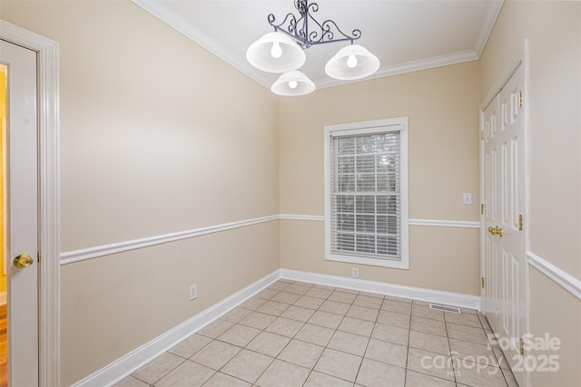 empty room with a notable chandelier, ornamental molding, and light tile patterned floors