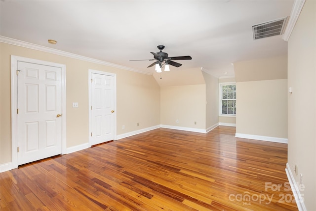 spare room with vaulted ceiling, hardwood / wood-style flooring, ceiling fan, and crown molding