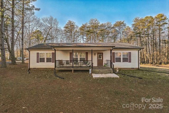 ranch-style house featuring covered porch and a front yard