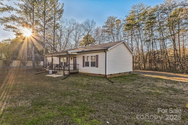 rear view of property with a porch and a lawn