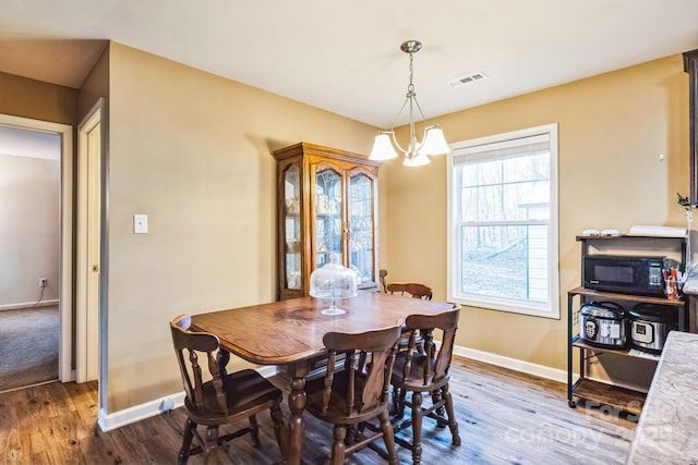 dining space with an inviting chandelier and hardwood / wood-style flooring