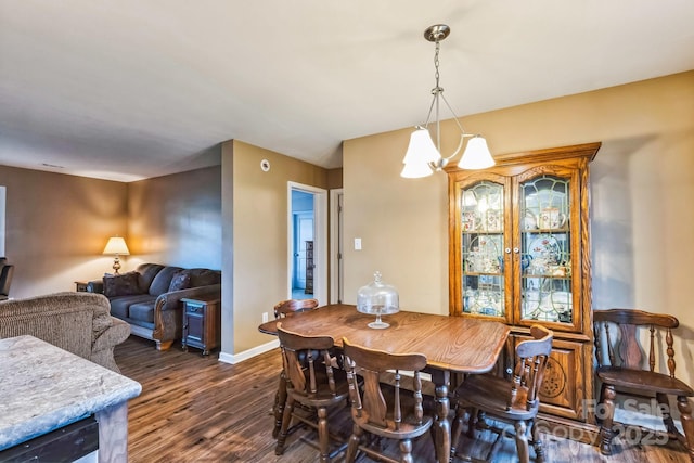 dining space featuring dark hardwood / wood-style flooring and a chandelier