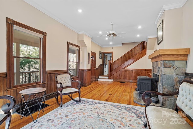 sitting room with ceiling fan, ornamental molding, and light hardwood / wood-style floors