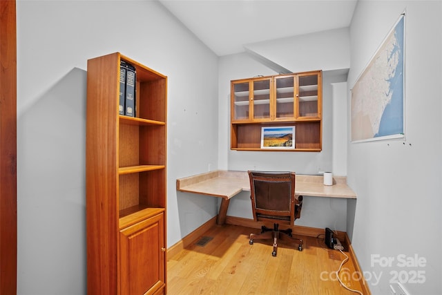 office space featuring built in desk and light hardwood / wood-style flooring