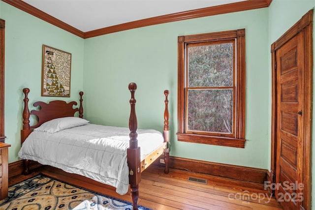 bedroom featuring hardwood / wood-style floors and crown molding