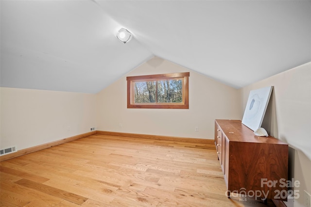 bonus room with lofted ceiling and light wood-type flooring