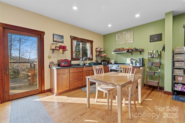 dining space with sink and light wood-type flooring