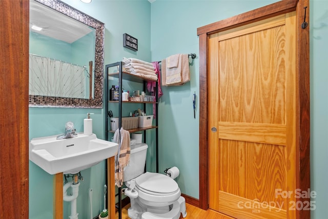 bathroom featuring toilet, hardwood / wood-style flooring, and sink