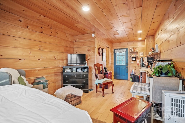 bedroom featuring light wood-type flooring, wooden walls, and wooden ceiling