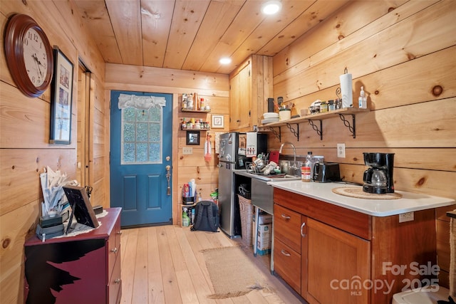 kitchen with wood walls, light hardwood / wood-style floors, and wood ceiling