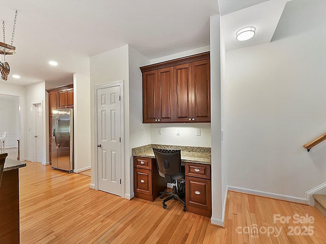 office area with built in desk and light hardwood / wood-style flooring