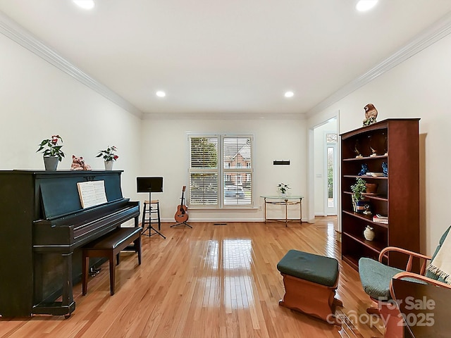 living area featuring crown molding and wood-type flooring