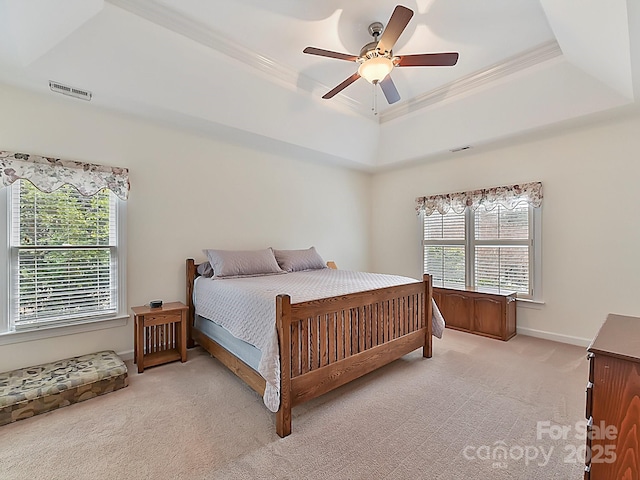 carpeted bedroom featuring a raised ceiling, crown molding, and ceiling fan