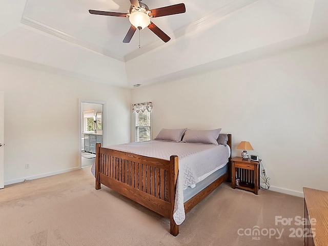 carpeted bedroom featuring ceiling fan and a tray ceiling