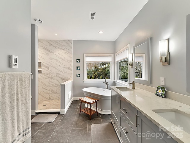 bathroom featuring tile patterned floors, plus walk in shower, and vanity