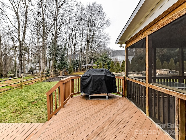 wooden deck featuring a sunroom, area for grilling, and a lawn