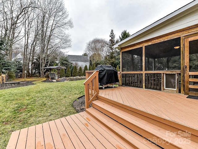 wooden terrace featuring a sunroom, a grill, and a yard