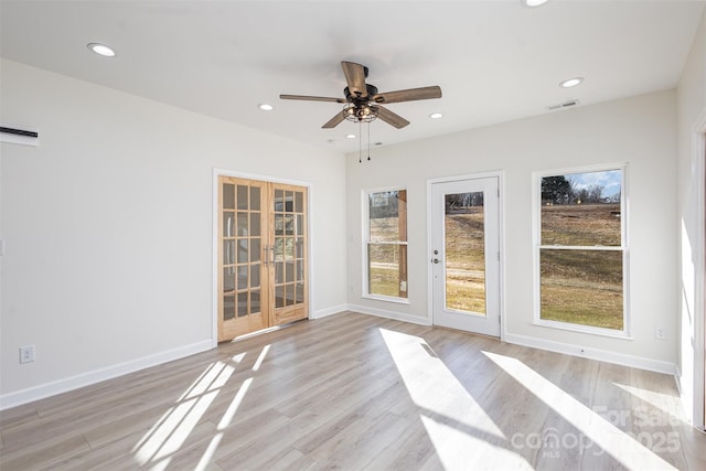 empty room featuring ceiling fan, light hardwood / wood-style flooring, and french doors