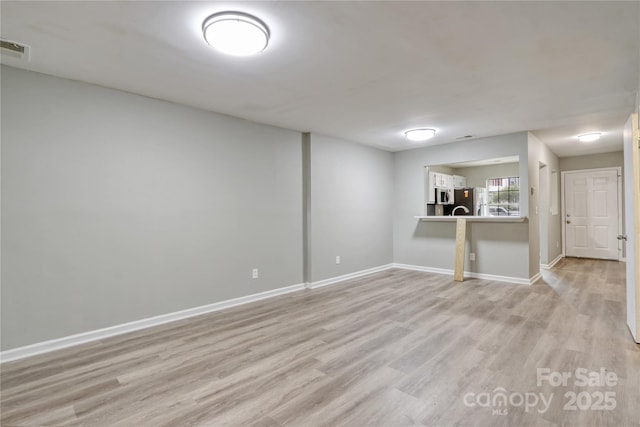 unfurnished room with light wood-type flooring