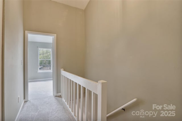 hall with light colored carpet