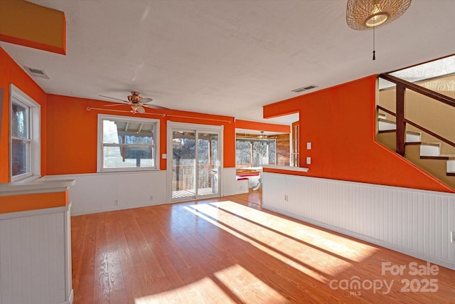 unfurnished living room featuring ceiling fan, plenty of natural light, and light hardwood / wood-style flooring