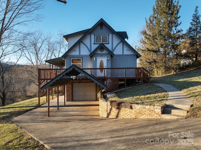 tudor-style house with a garage, a front yard, and a wooden deck