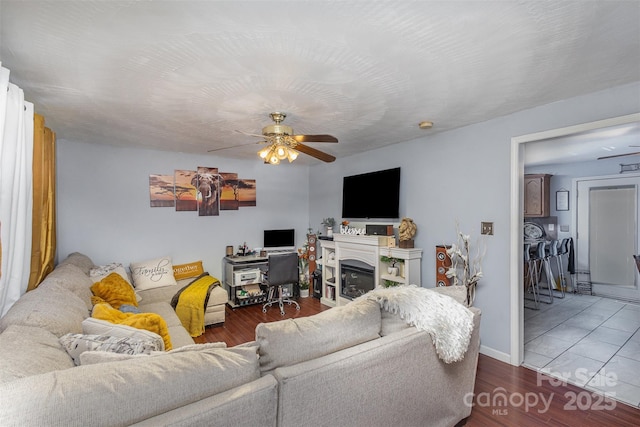 living room featuring dark wood-type flooring and ceiling fan